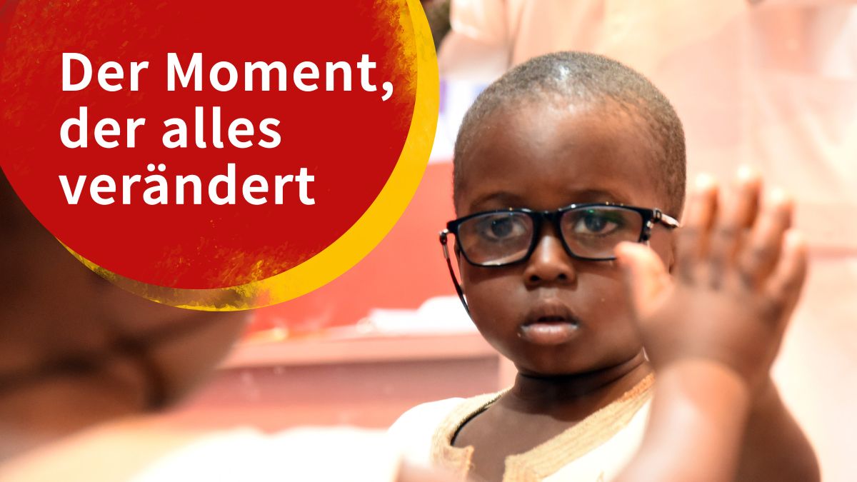 Afrikanischer Junge mit Brille schaut in den Spiegel