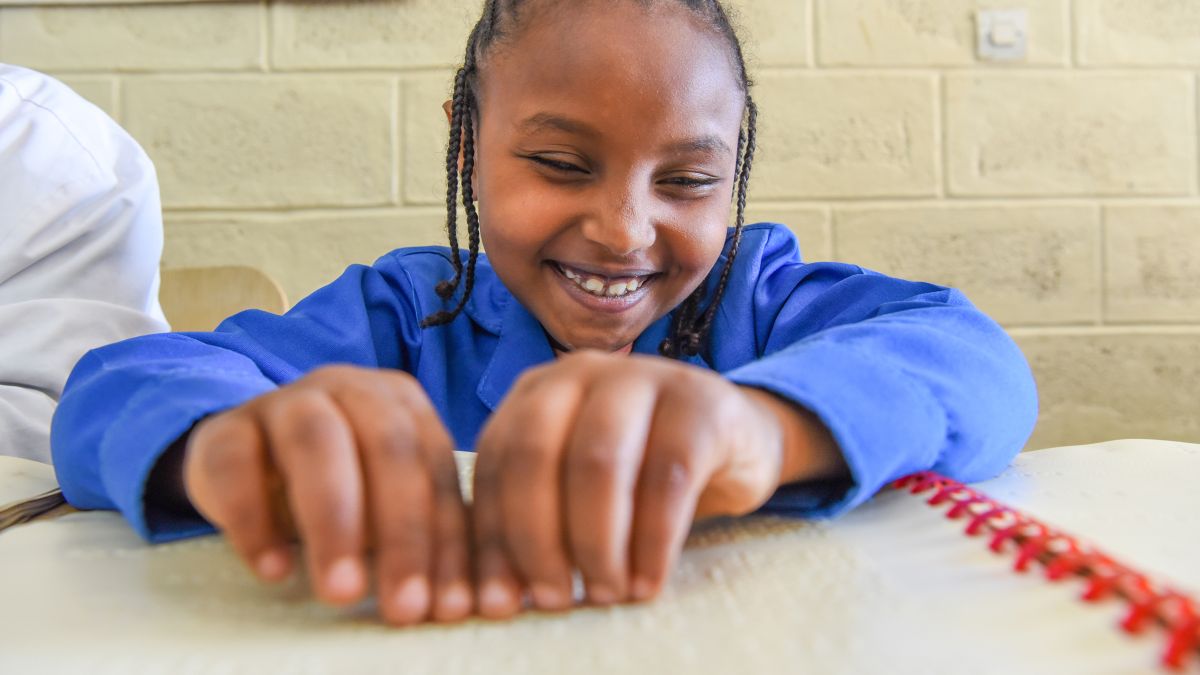 Blindes Mädchen liest mit den Händen