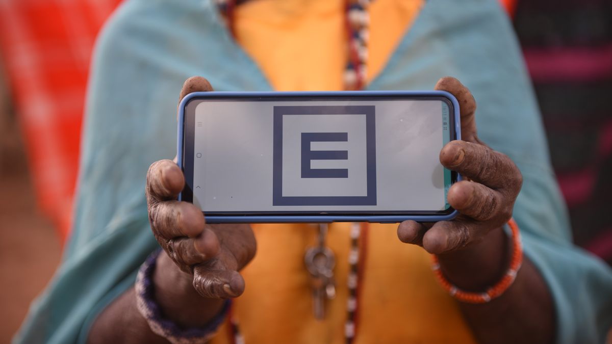 Eine Person hält einen Handyscreen mit Sehtest vor sich hoch