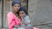 Momina sitzt auf dem Schoß ihrer Mutter