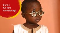 Kleiner afrikanische Junge mit Sehtestbrille zur Sehschärfenbestimmung
