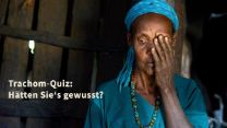 Afrikanische Frau hält sich ein Auge zu. Aufschrift auf Bild: "Trachom-Quiz: Hätten Sie's gewusst?"