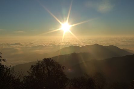 Über Bergen geht die Sonne auf.