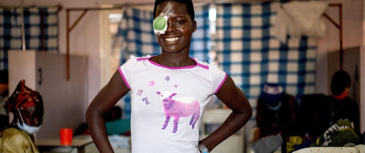Lachendes afrikanisches Teenager-Mädchen mit Augenverband