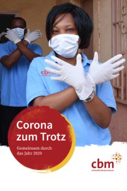 Eine afrikanische Frau mit weißen Schutzhandschutzen kreuzt die Arme zu einem X; auf einem roten Punkt steht: Corona zum Trotz