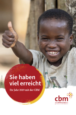 Ein Junge aus Afrika lacht und streckt den Daumen hoch