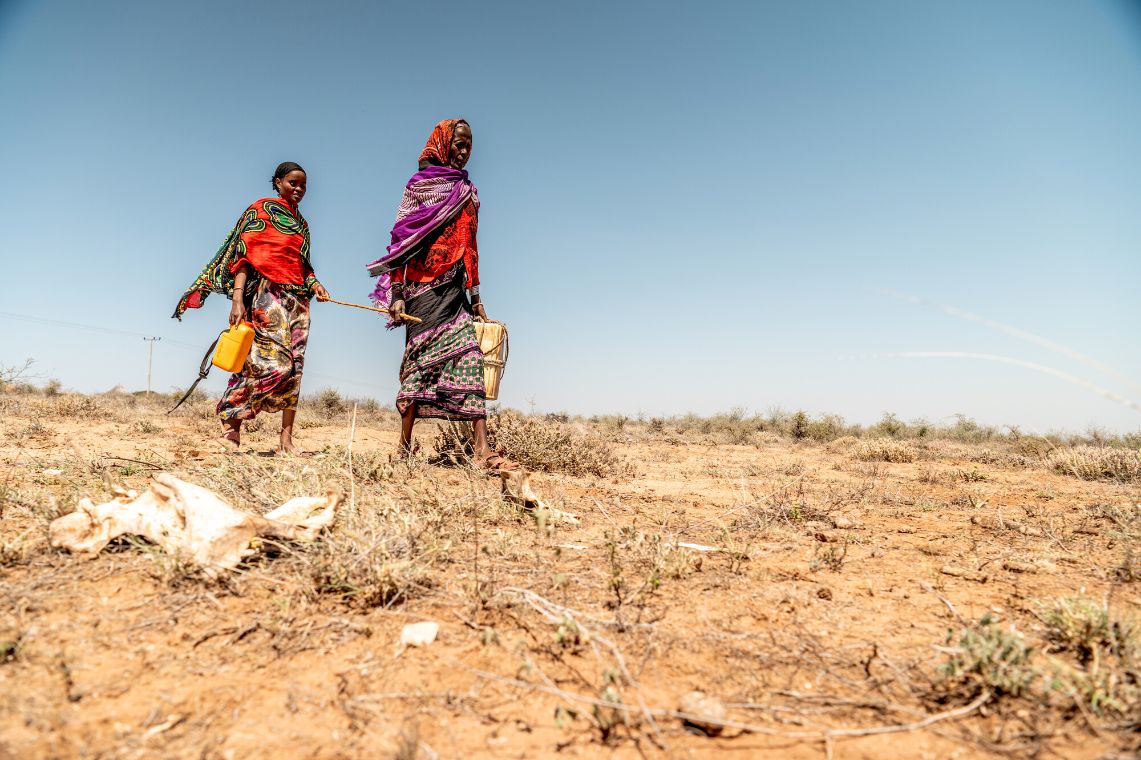 Porträt einer jungen Frau, die einen Stock in der linken Hand hält.