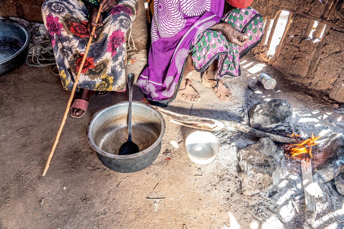 Porträt einer jungen Frau, die einen Stock in der linken Hand hält.