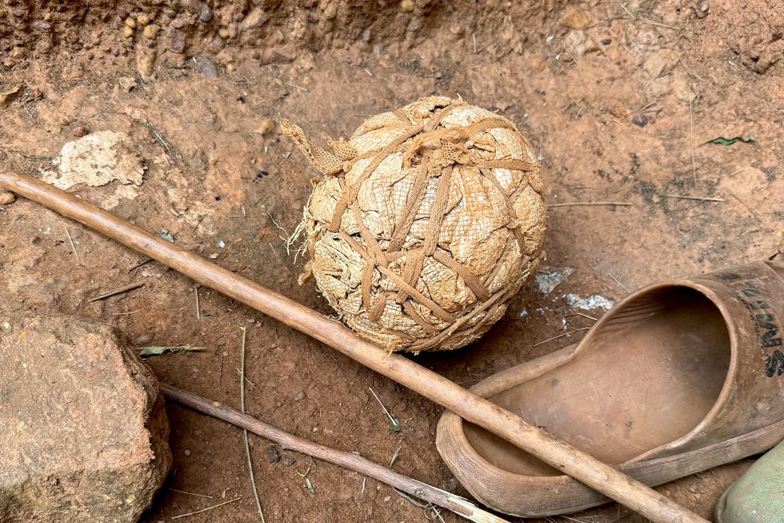 Am Boden liegt neben einem Plastikschuh ein ballrunder Klumpen aus Plastik, der mit Schnur zusammengehalten ist.
