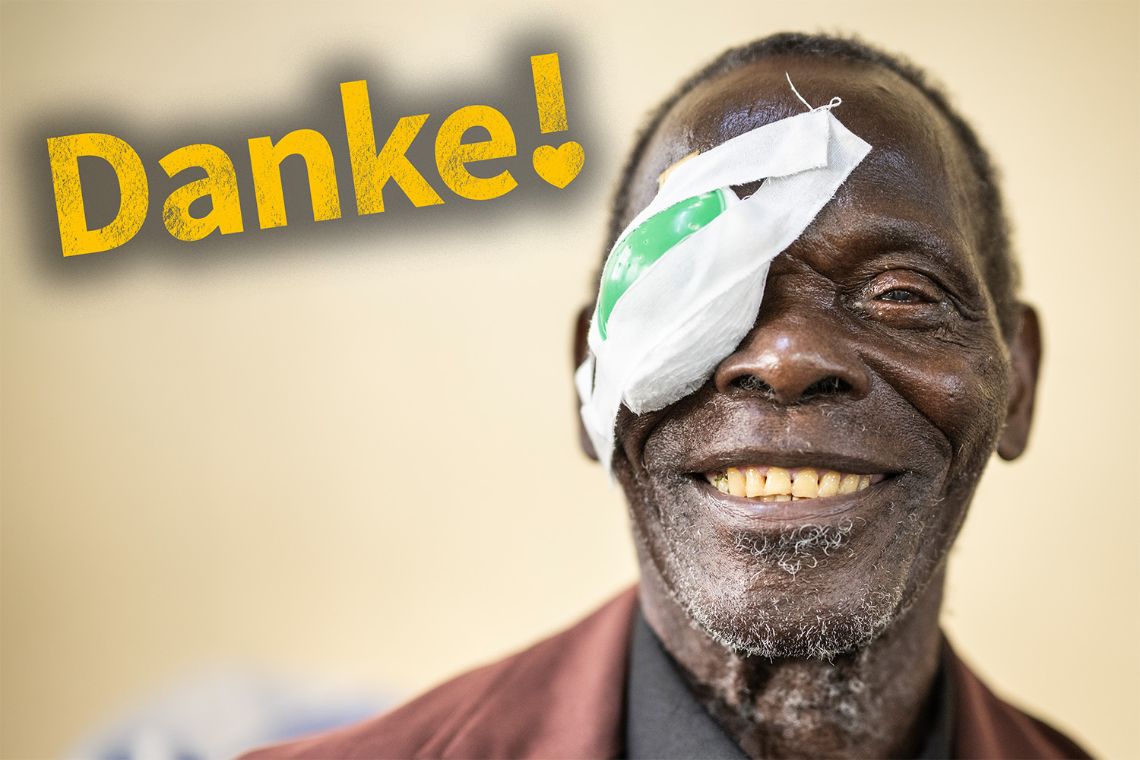 Älterer lachender Mann mit Augenverband.