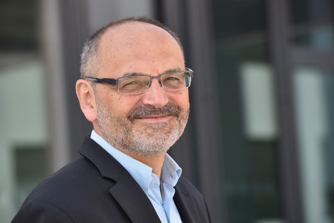 Mann im Anzug vor einer Glastür