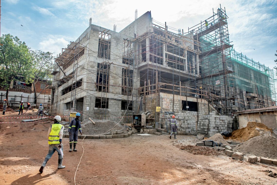 Dreigeschossiges eingerüstetes Betongebäude im Rohbau.