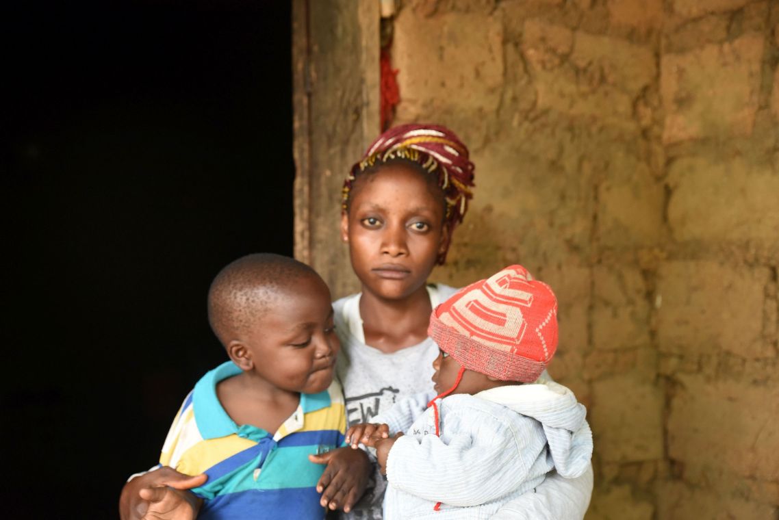 Junge afrikanische Frau mit zwei kleinen Kindern vor einer Mauer