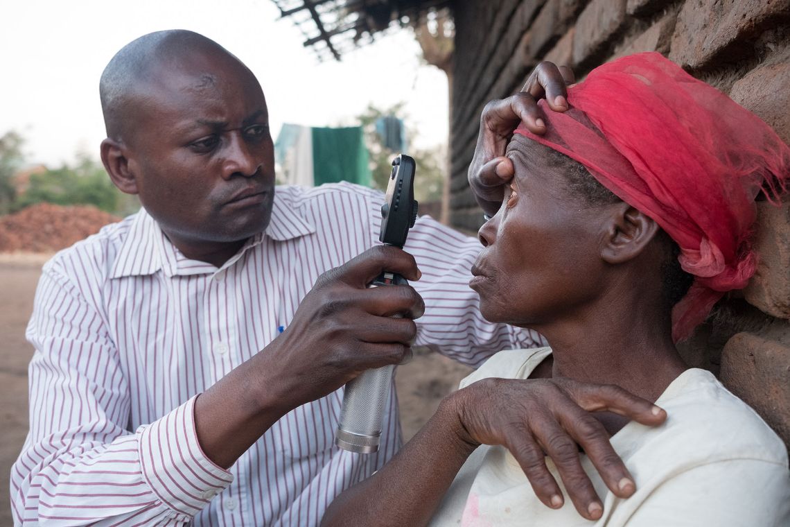 Augenuntersuchung bei einer Frau in einem malawischen Dorf