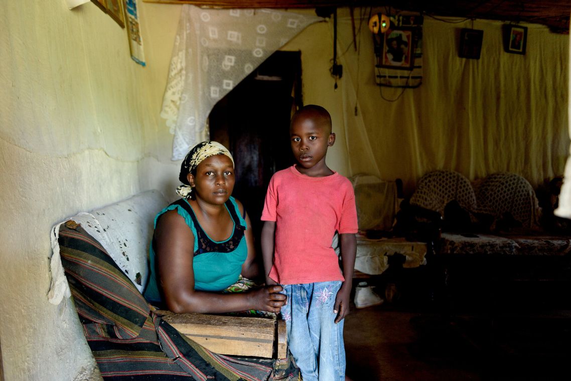Eine afrikanische Frau und ein kleiner afrikanischer Junge im Wohnraum einer Hütte
