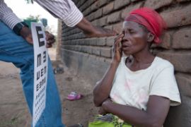 Sehtest bei einer Frau in einem malawischen Dorf