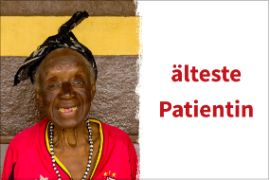 Eine alte, bunt gekleidete afrikanische Frau, die lächelt.
