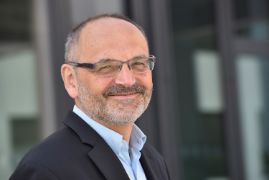Mann im Anzug vor einer Glastür