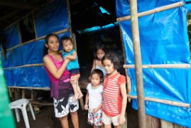 Philippinische Familie steht vor ihrer Hütte