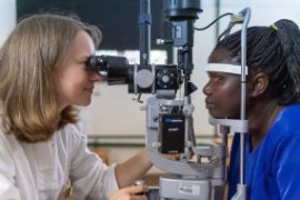 Deutsche Augenärztin untersucht tansanische Patientin an den Augen