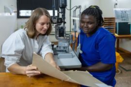 Deutsche Augenärztin bespricht mit tansanischer Patientin Untersuchungsergebnisse