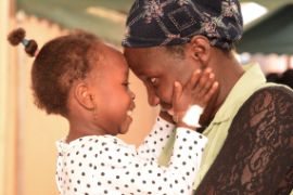 Afrikanisches Mädchen berührt seine Mutter an den Wangen