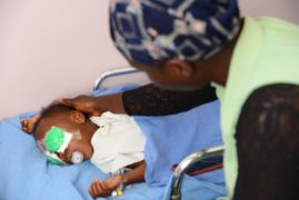 Afrikanisches Mädchen mit Augenverbänden nach einer Operation am Grauen Star