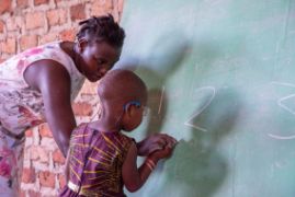 Afrikanisches Mädchen schreibt Zahlen an eine Tafel