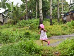 Kleines philippinisches Mädchen rennt im Freien herum
