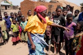 Afrikanische Frau, umringt von Kindern