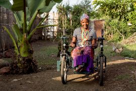 Eine junge Frau sitzt im Rollstuhl.