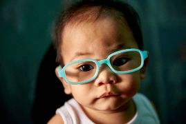 Ein Baby mit Brille.