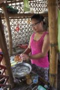 Junge philippinische Frau in einer Hütte beim Geschirrspülen