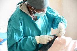 Eine Frau in OP-Kleidung beim Operieren