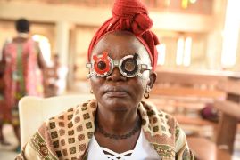 Eine Frau mit rotem Kopftuch und Sehtestbrille in einer Kirche