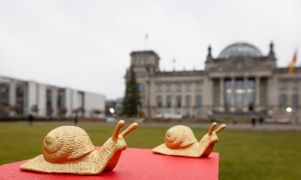 Zwei goldene Plastikschnecken sitzen vor dem Bundestag in Berlin.
