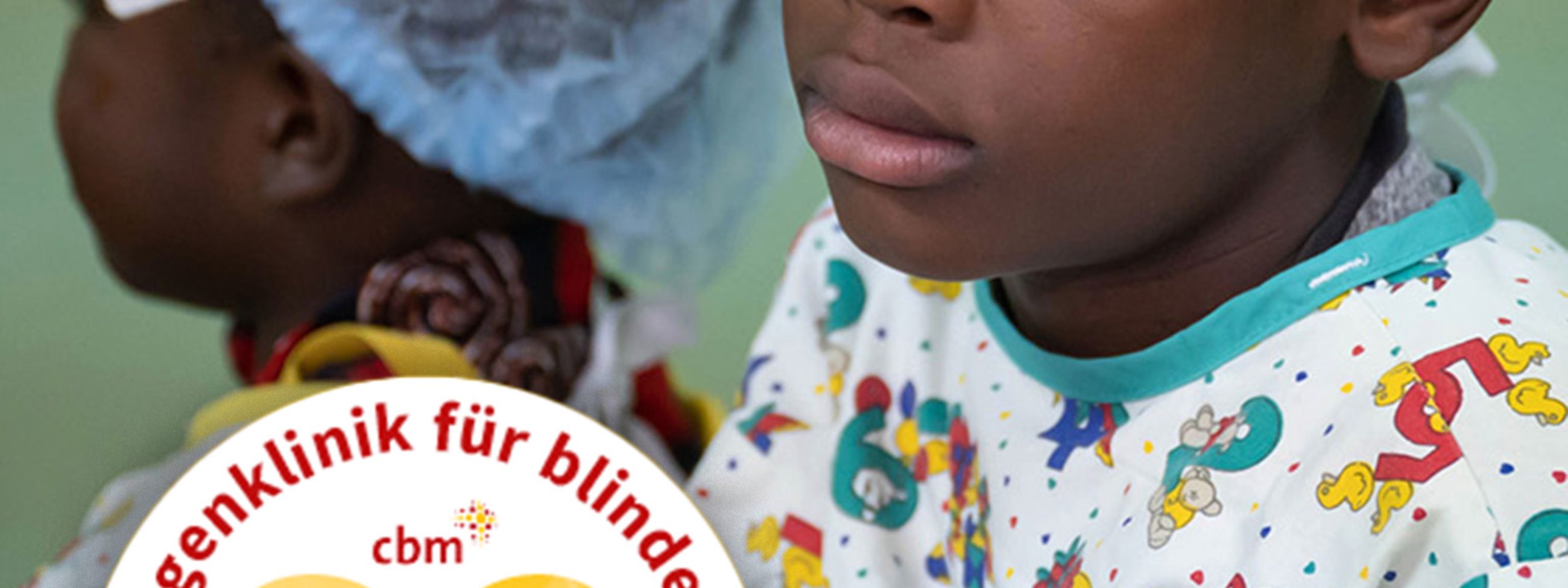 Vier Kinder im Alter von etwa fünf bis 14 Jahren, dazu eine Frau mit Baby sitzen nebeneinander. Die Kinder tragen OP-Kleidung und haben jeweils ein Pflaster auf der Stirn.