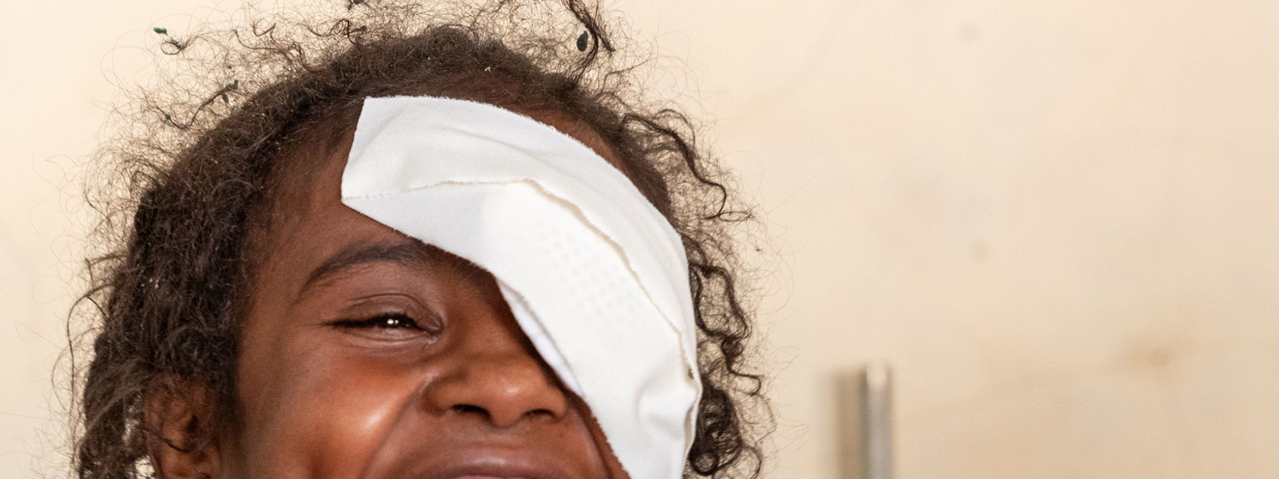 Lachendes Mädchen mit Augenverband.