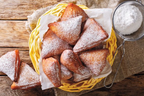 Teigtaschen mit Puderzucker in einem Korb