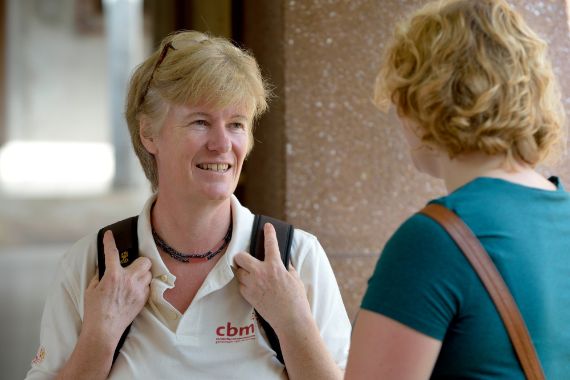 Eine Frau mit Rucksack im Gespräch mit einer anderen Frau.