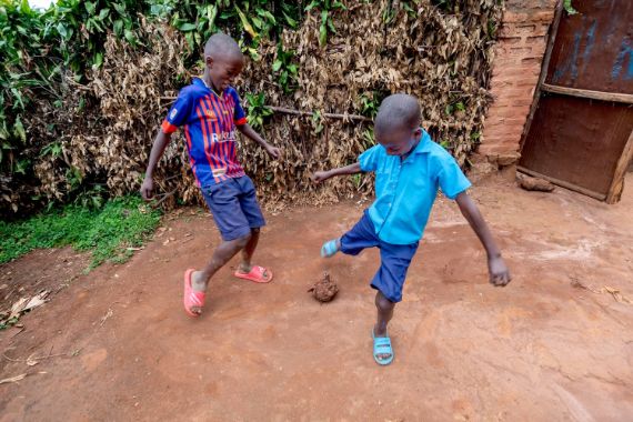 Zwei Jungen spielen Fußball – mit einem aus Plastik und Kordel zusammschengeschnürten Klumpen.