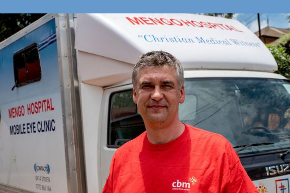 Ein Mann steht vor einem LKW mit der Aufschrift &quot;Mengo Hospital - Mobile Clinic&quot;