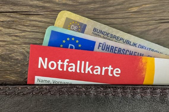 Eine Geldbörse aus der drei Karten herausschauen. Auf der vordersten Karte steht "Notfallkarte"