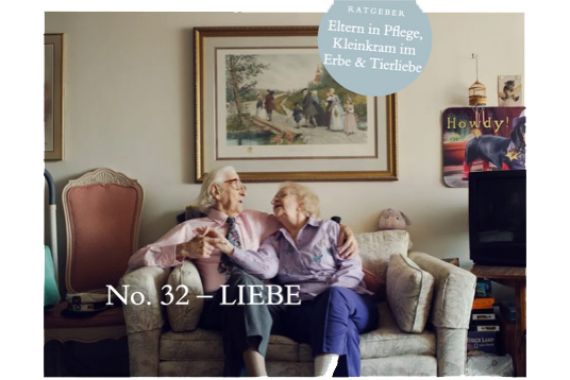 Ein altes Paar sitzt auf dem Sofa unter einem Bild.