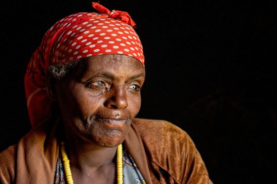 Eine Frau mit Kopftuch und entzündeten Augen. 