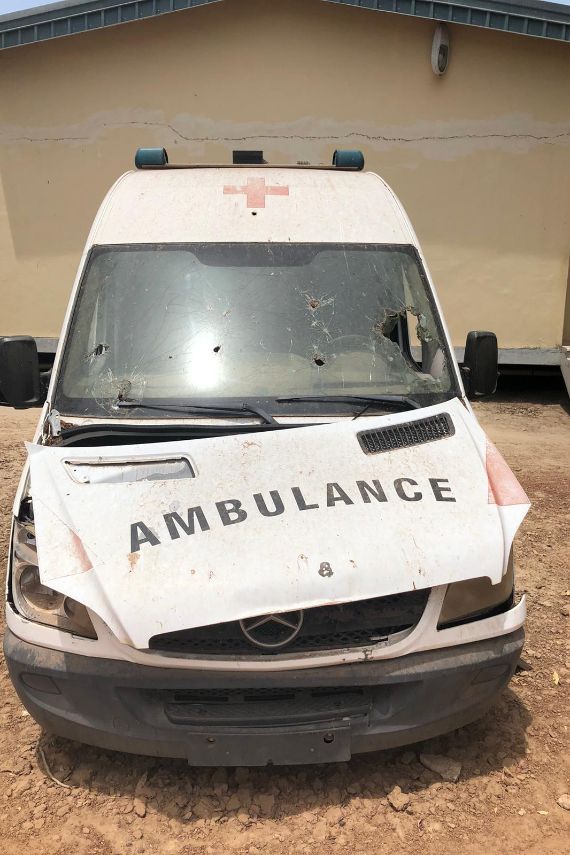 Ein Krankenwagen mit verbeulter Motorhaube und Einschusslöchern.